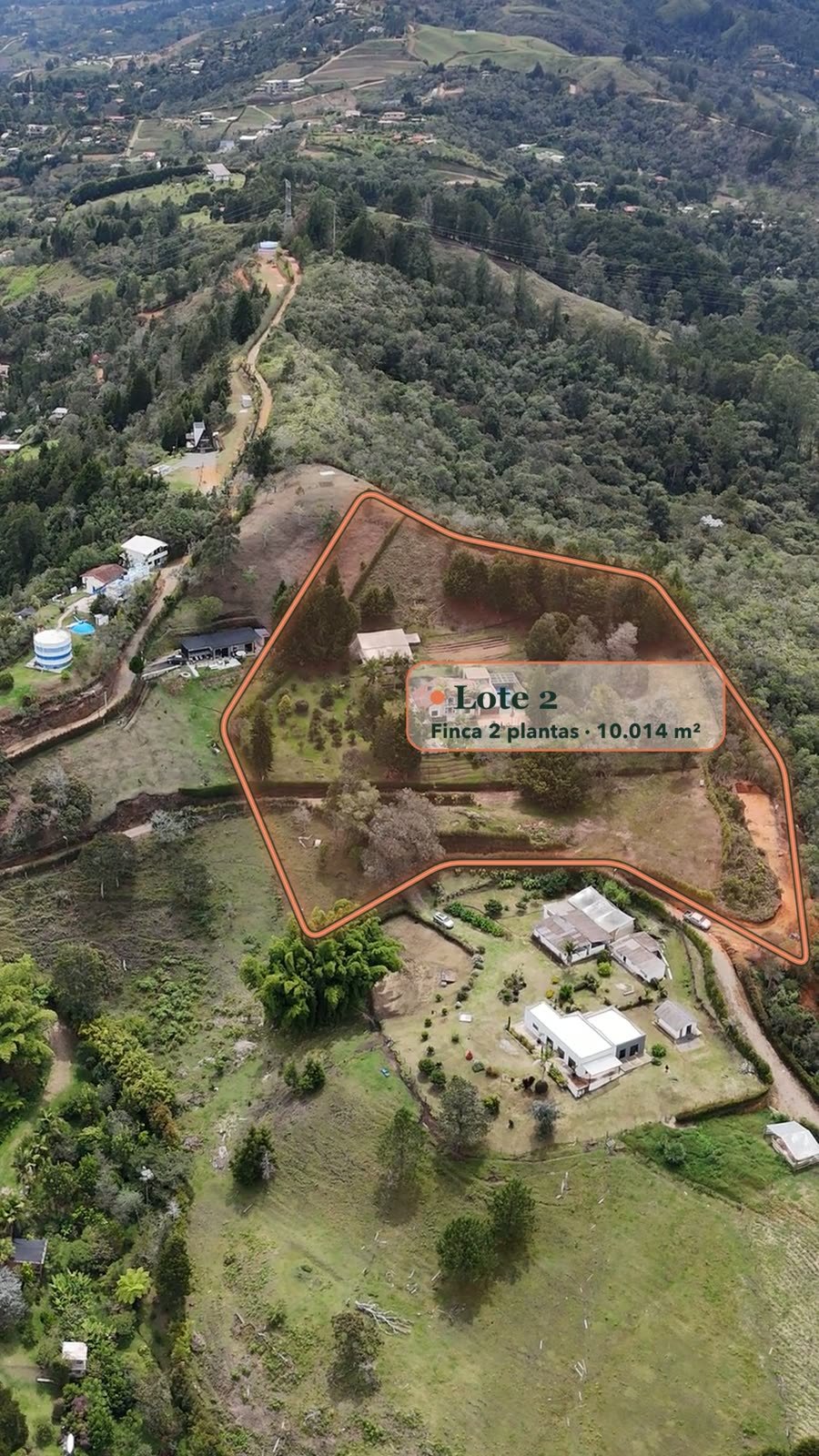 Toma aérea con el lindero terracota del Lote 2, la casa, la cancha y el bosque