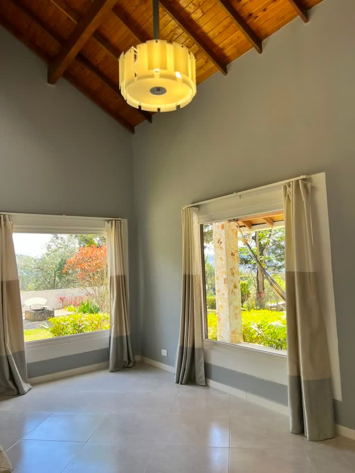 Habitación con techo en madera y ventanas al jardín